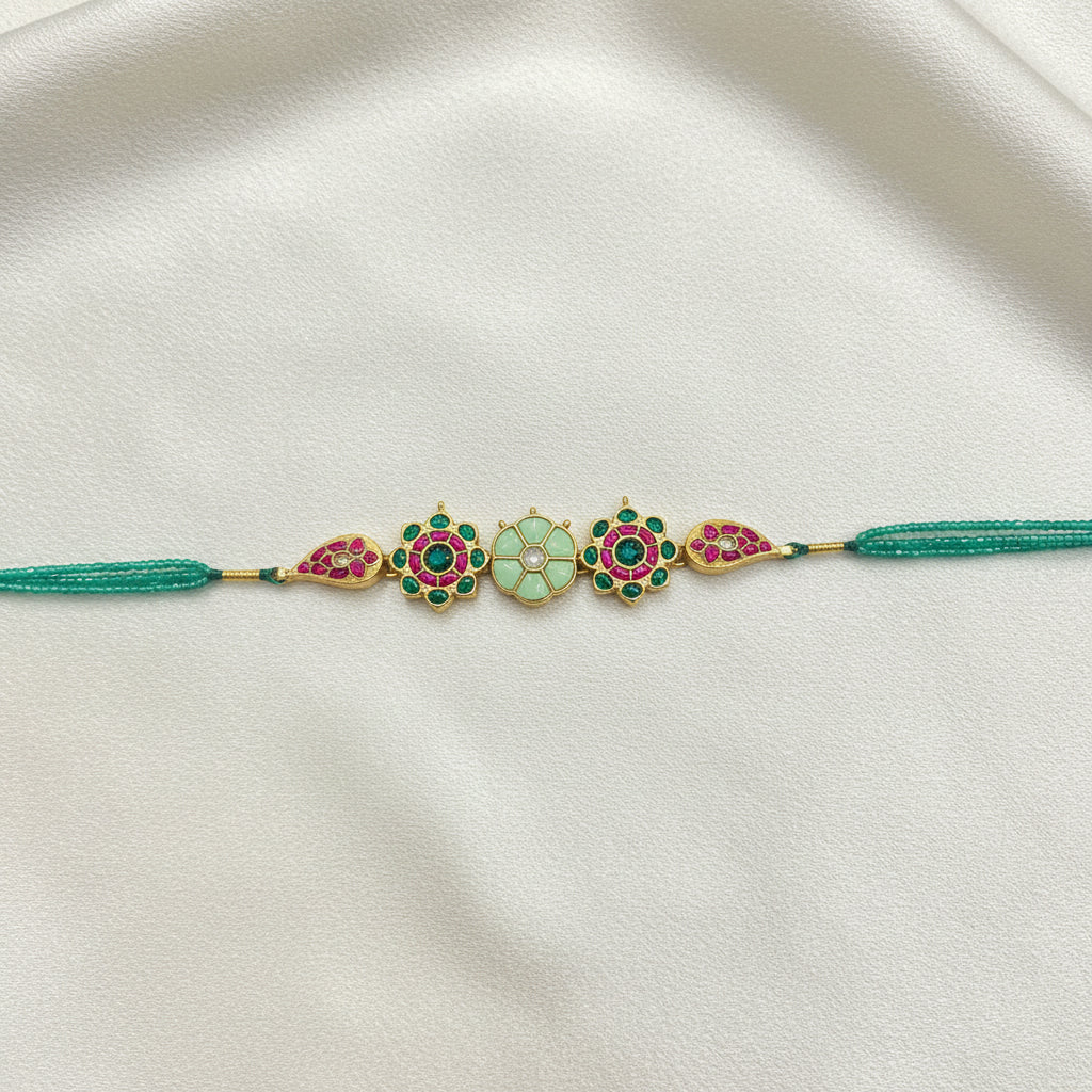 Decorative necklace with colorful beads and tassel on a textured gray surface