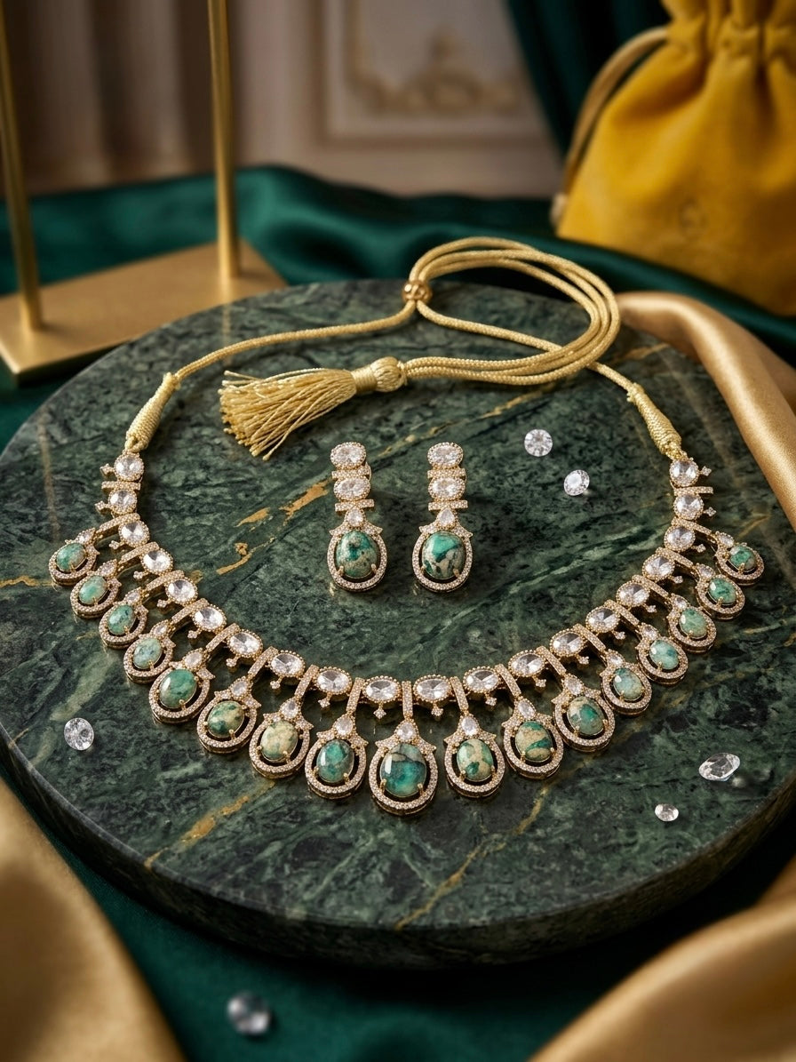 Moss Agate artificial gold-tone necklace and drop earring set displayed on green marble with crystal accents and gold tassel closure
