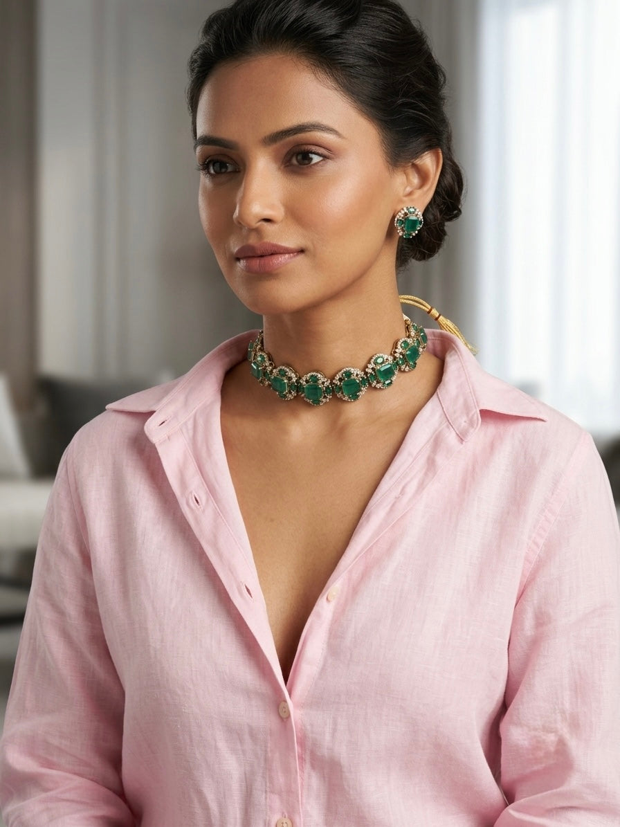 Woman wearing artificial green onyx Victorian choker necklace with matching stud earrings and gold tassel dori, styled with pink linen shirt for fusion bridal look