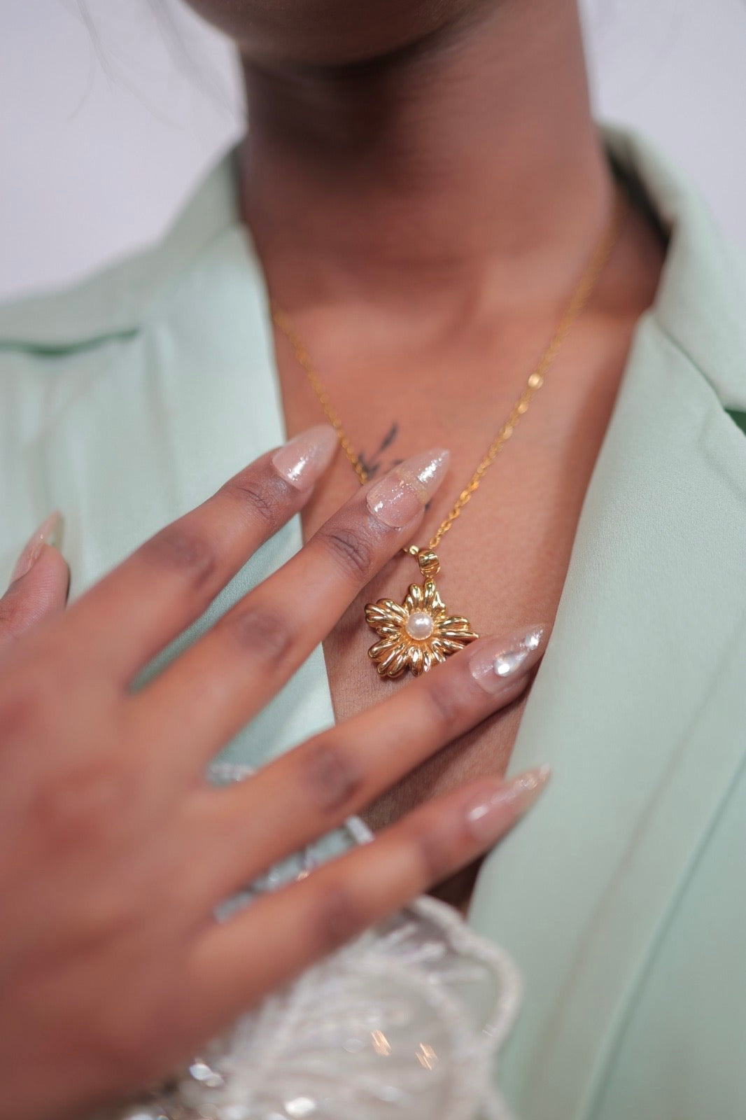 Gold plated anti-tarnish flower pearl chain  with pearl center bloom and delicate gold chain draped across hand.