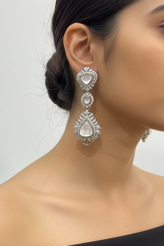 Close-up of mother of pearl teardrop statement earrings with sparkling crystal detailing, worn on model, ideal for wedding, festive and occasion wear styling.