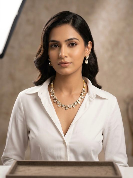 Model wearing gold-tone Polki Kundan triangle necklace with CZ stones and matching drop earrings styled with a white shirt for a contemporary bridal look